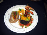 Filet Mignon on a bed of carmelized onions and sauteed tomatoes, topped with guacamole, melted cheddar and a mesquite shrimp skewer.